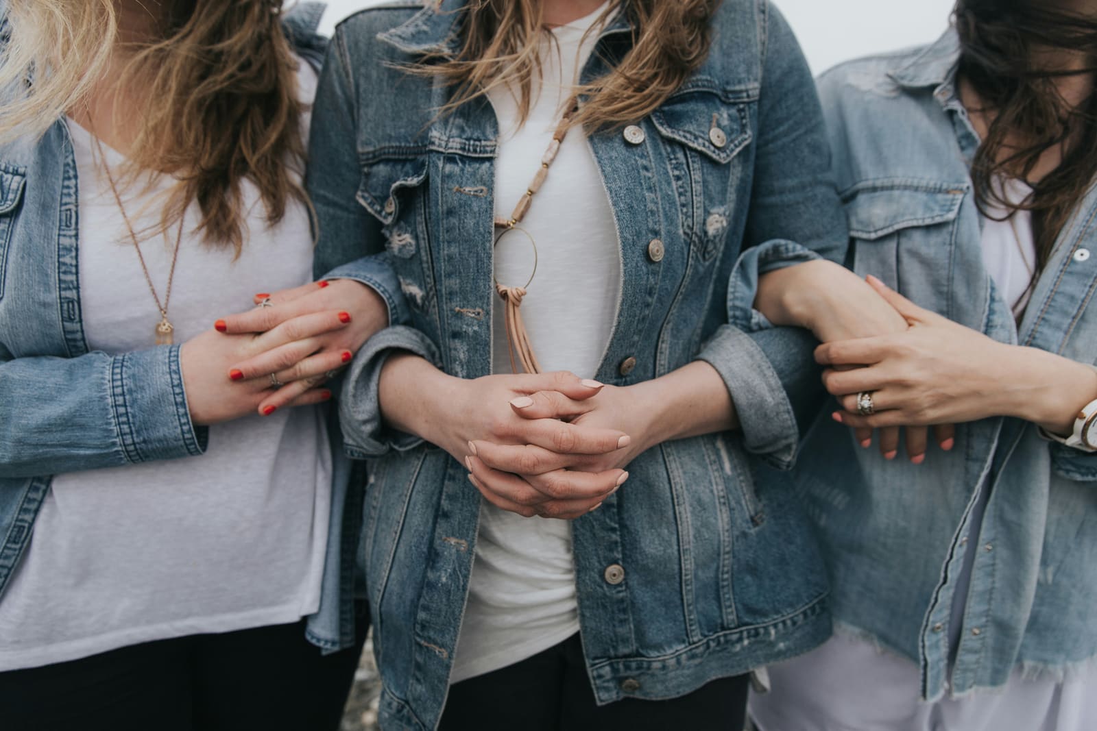 Drei Frauen stehen Arm in Arm – Verbundenheit und gegenseitige Unterstützung