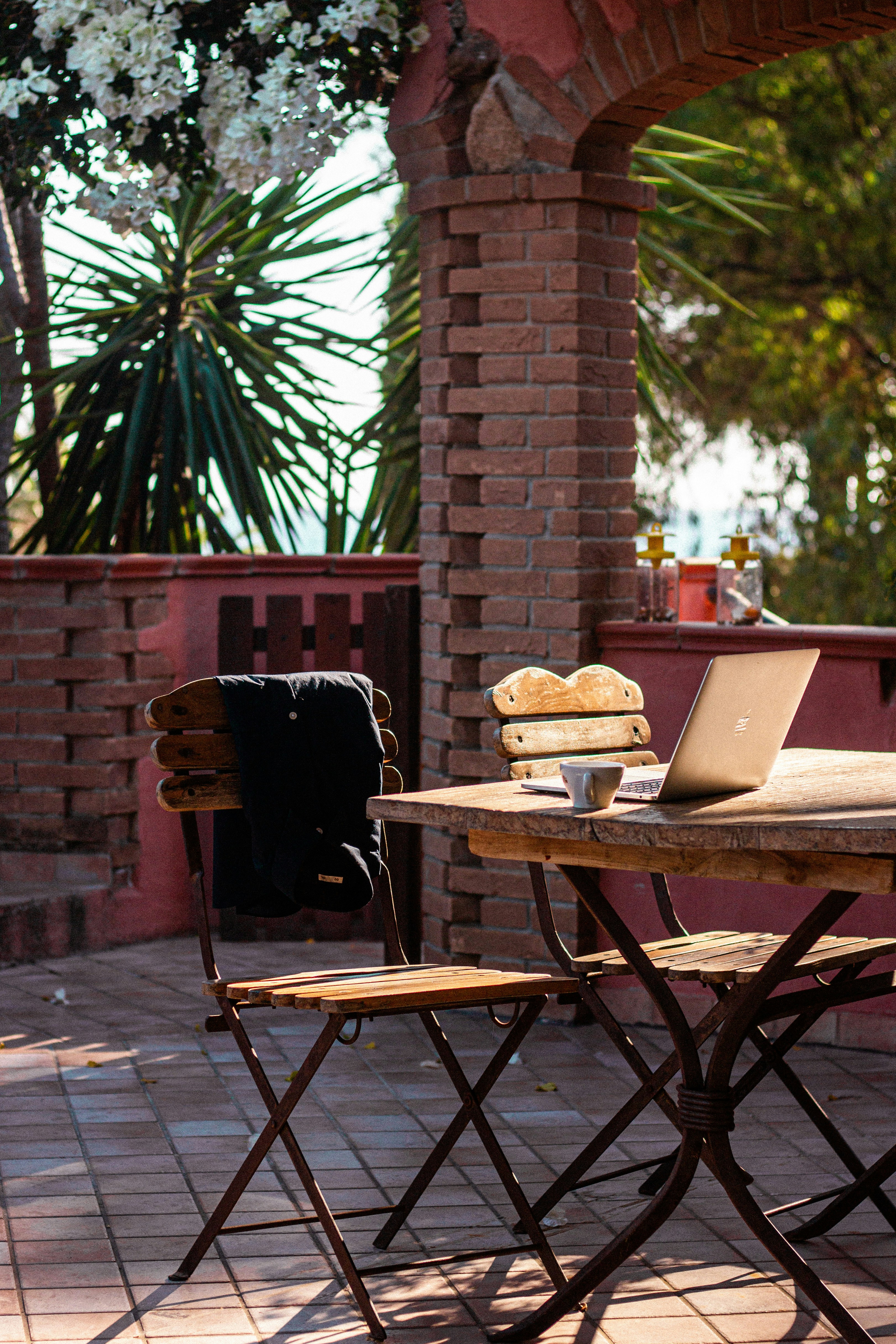 Laptop on a sunny outdoor terrace table