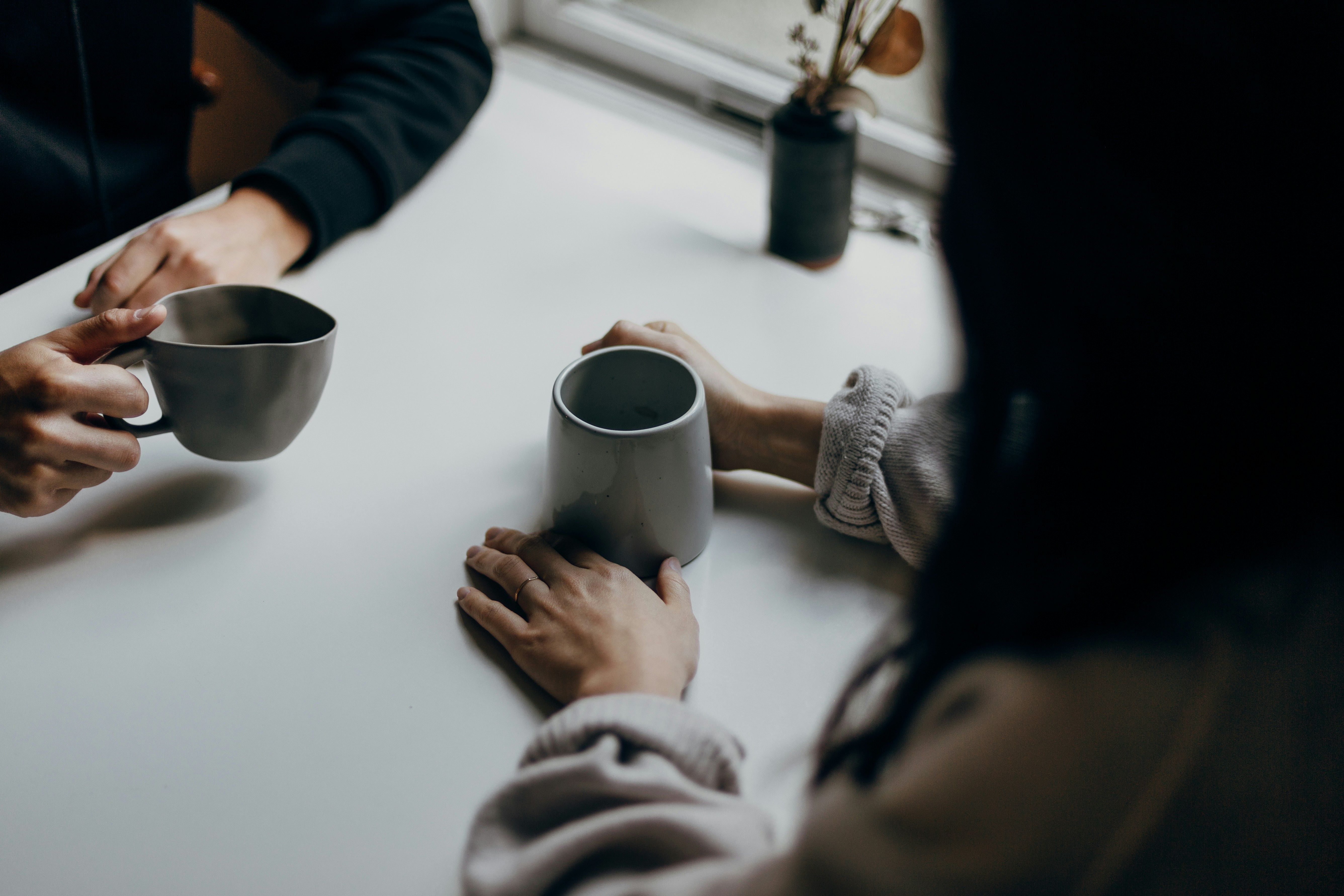 Dos personas sentadas juntas con tazas de café