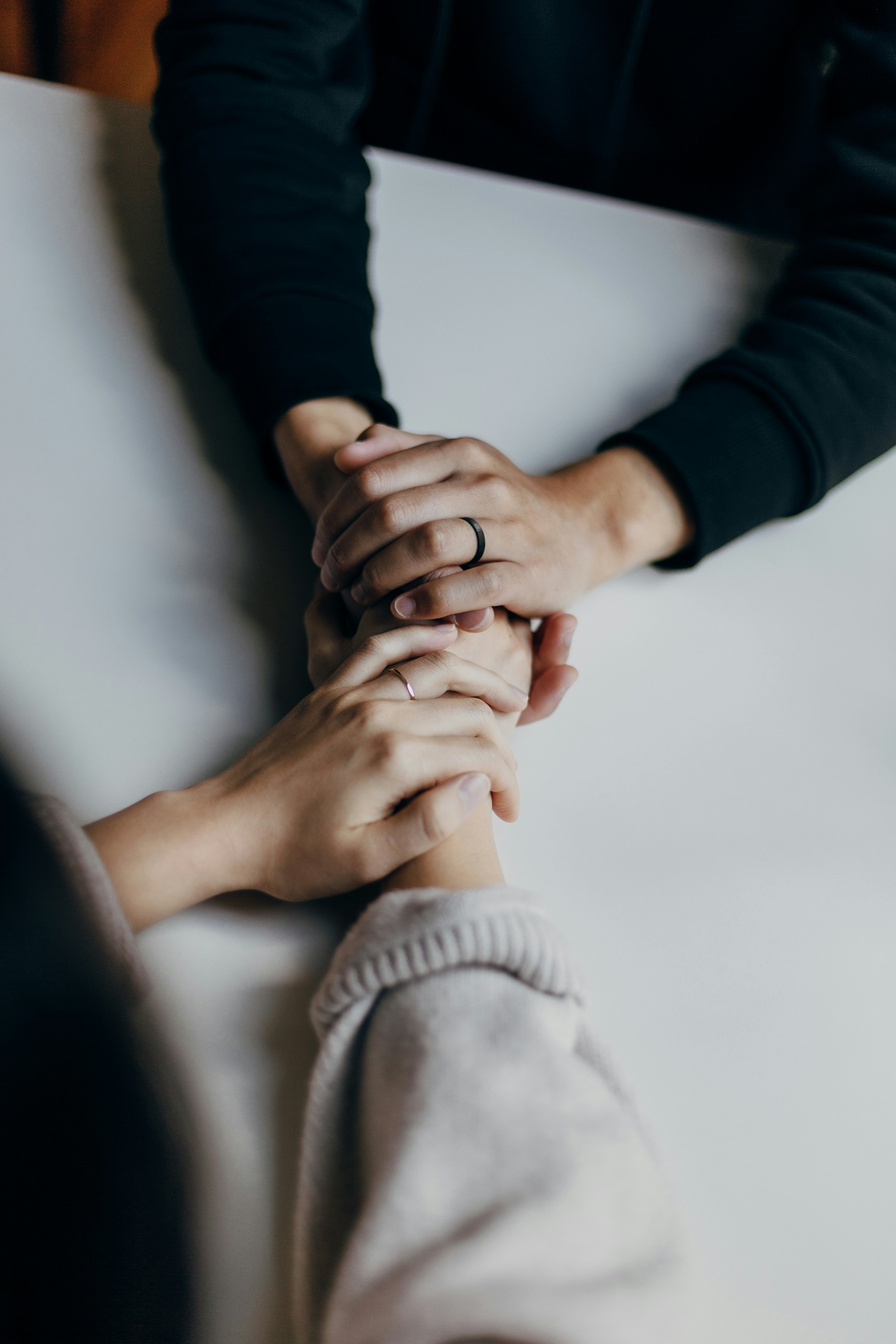 Two pairs of hands holding each other